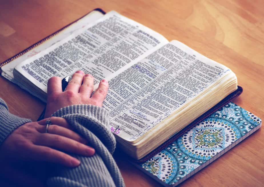 women reading bible at a brown desk with a blue design bookmark on the side